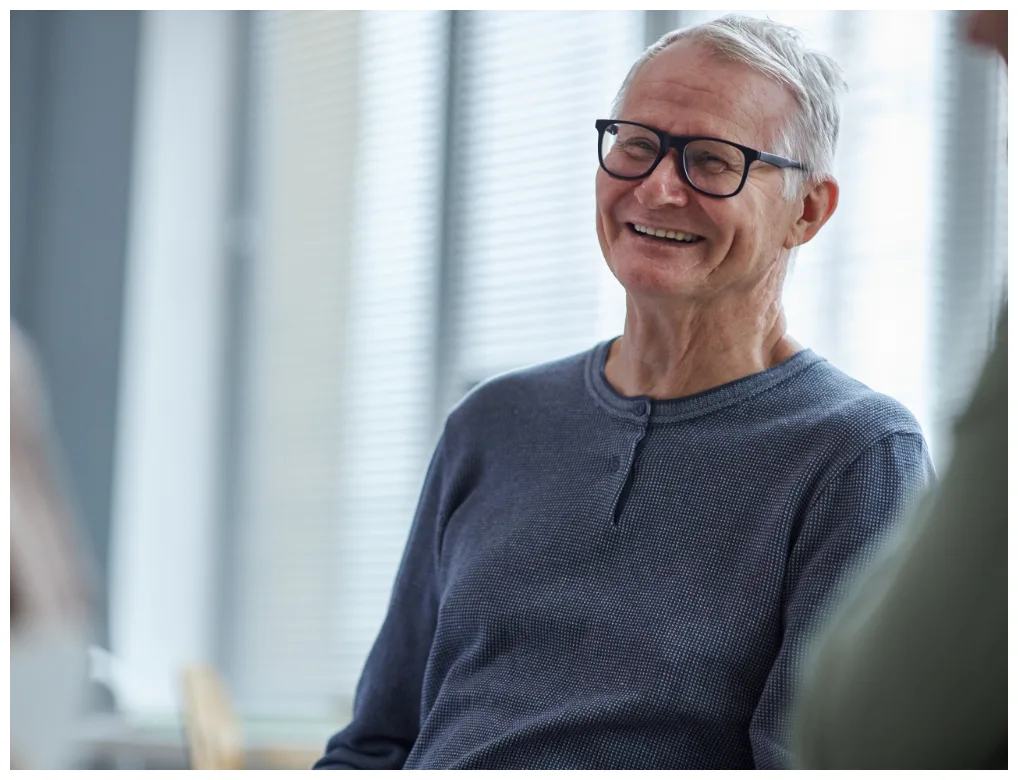 elderly man with glasses smiling