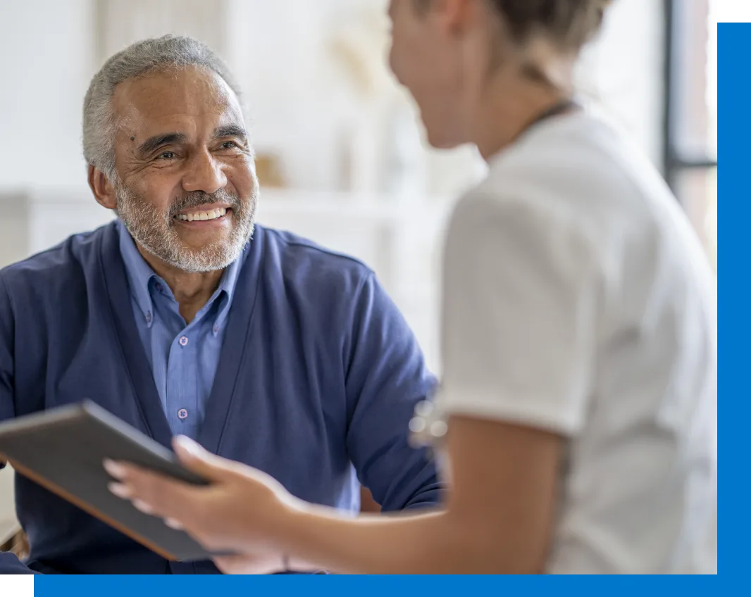 elderly man smiling while looking at care giver